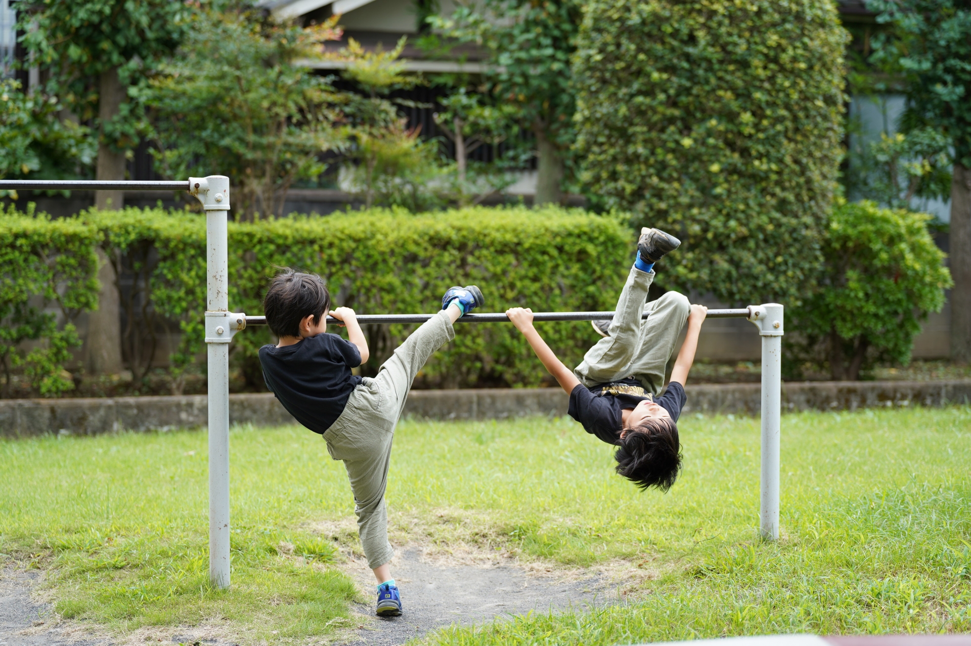 鉄棒をする男の子たち