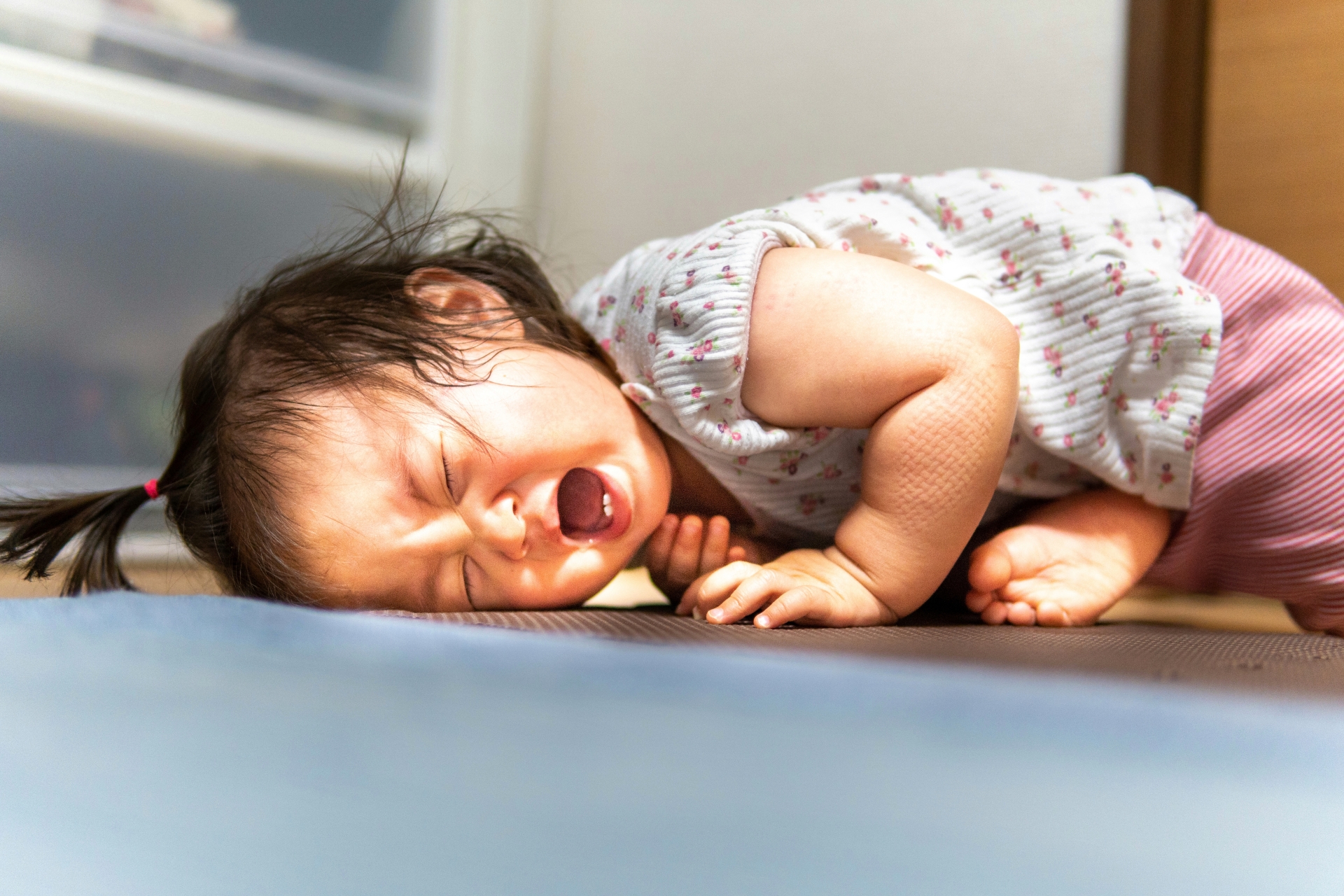 床に寝転ぶ大泣きの子ども