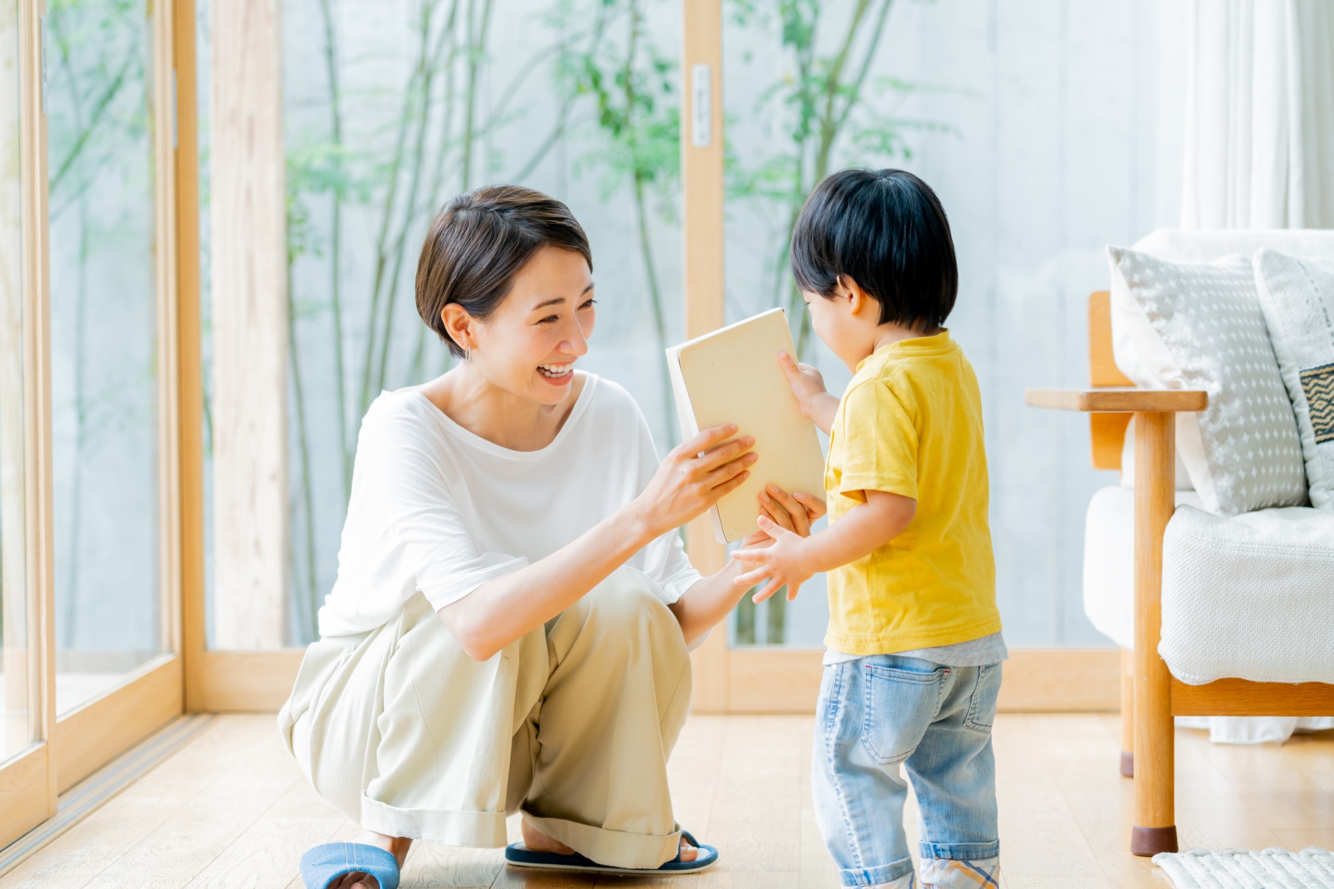子どもに絵本を渡すママ