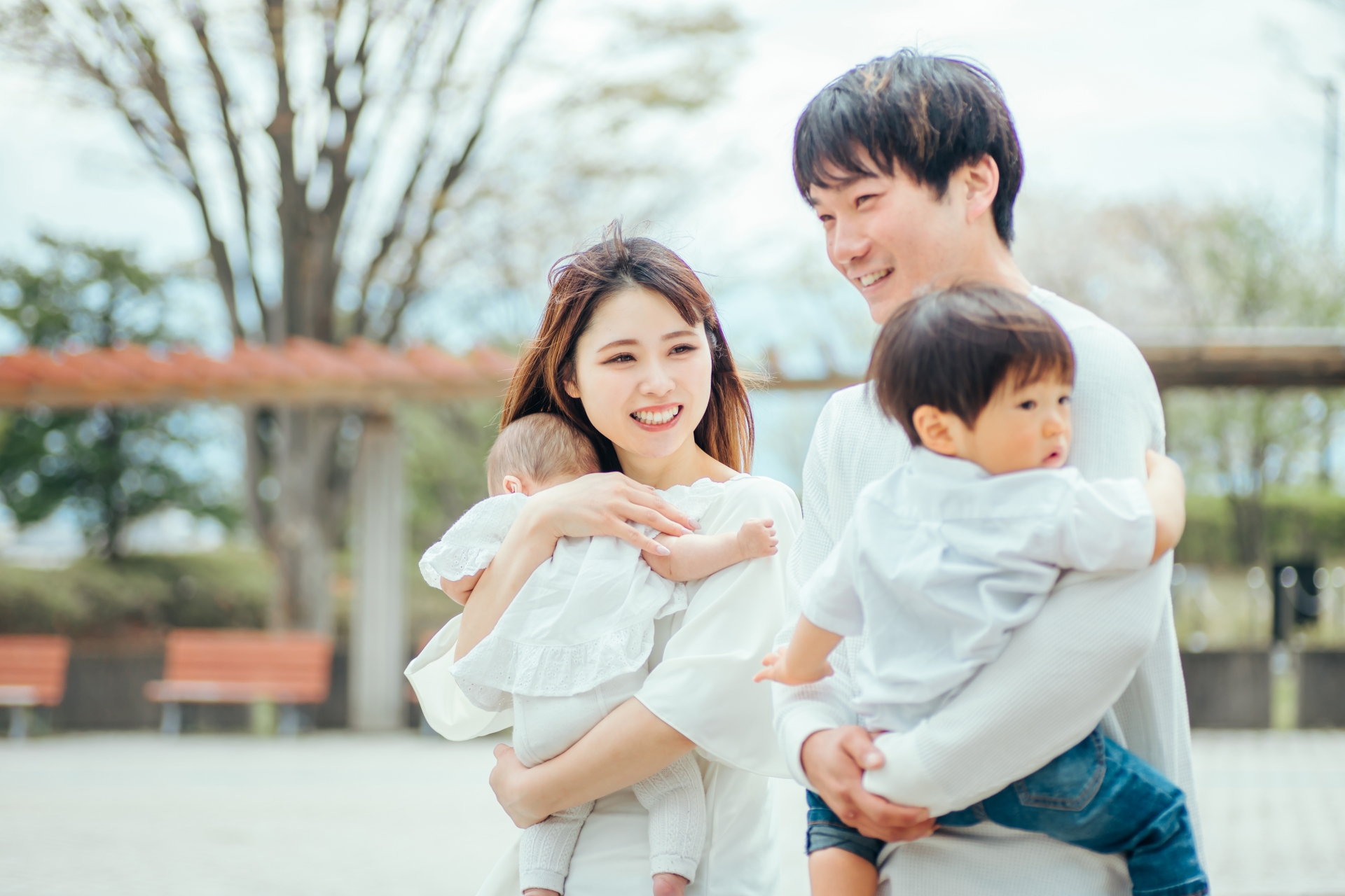子どもを抱っこする夫婦