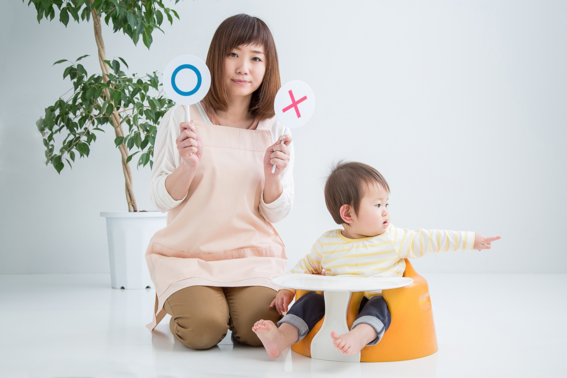 マルバツを持つ女性と赤ちゃん