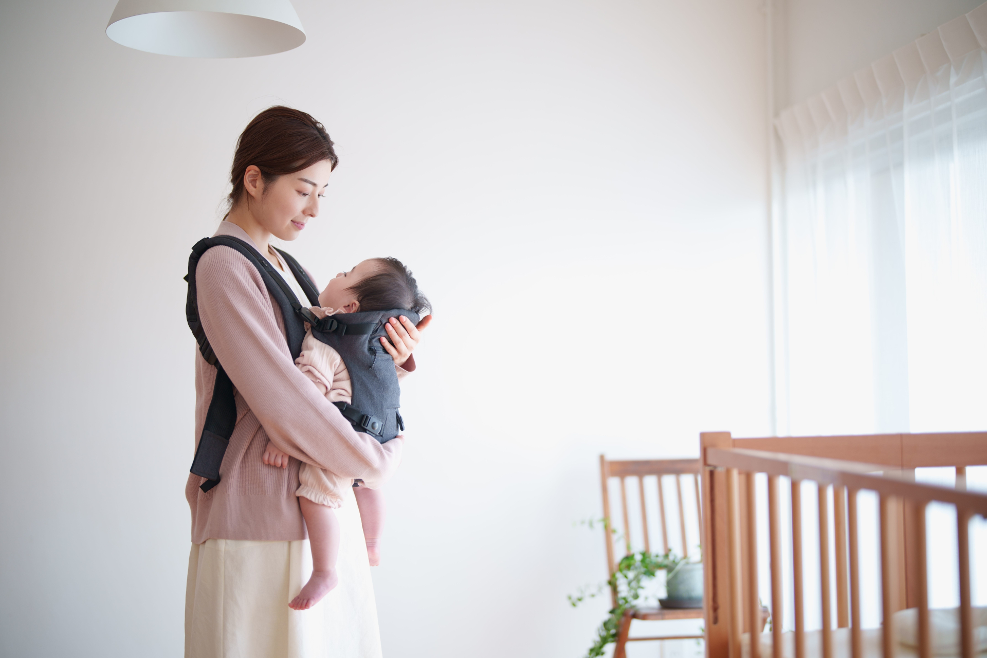抱っこ紐で子どもを抱っこするママ
