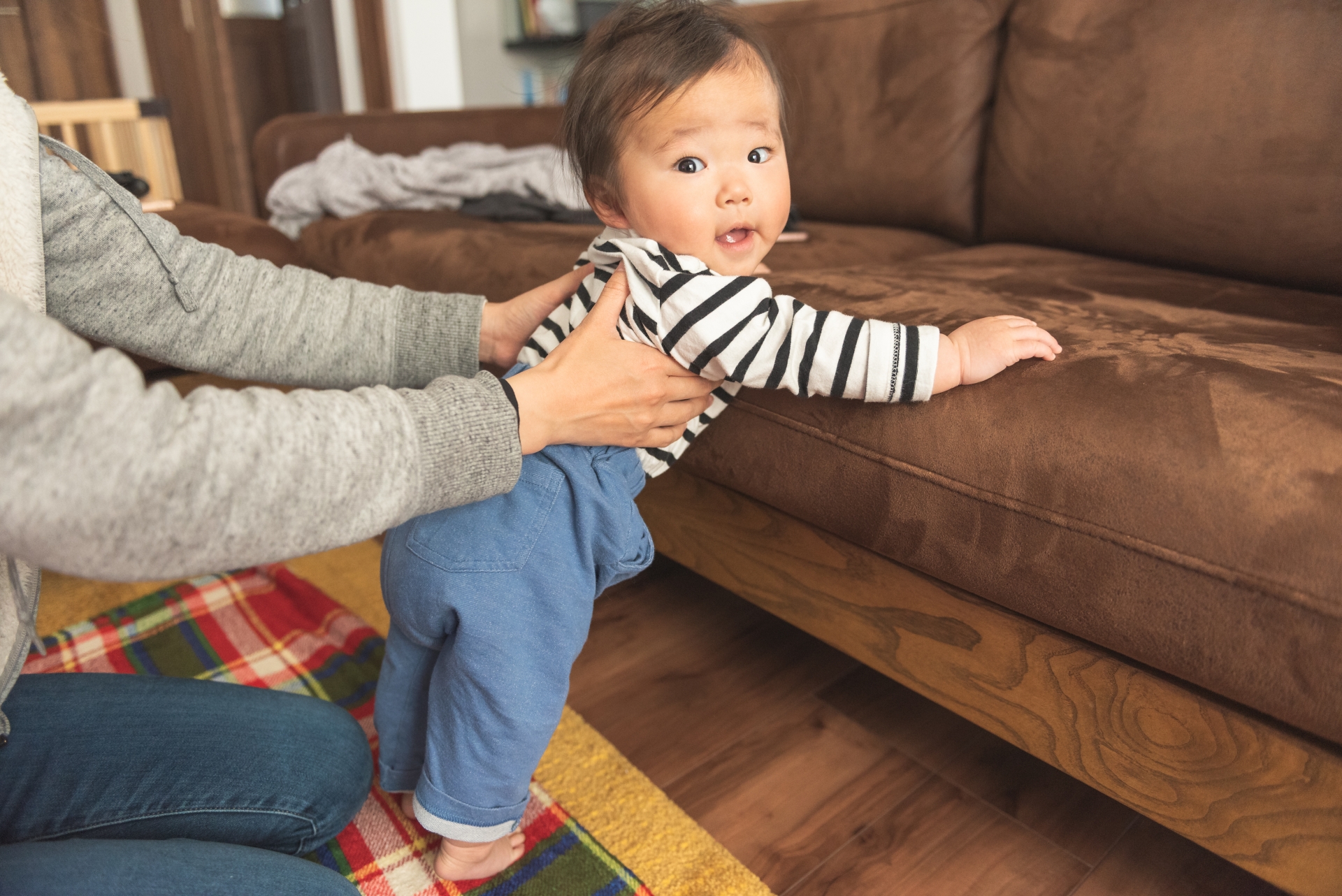 伝い歩きの練習をする赤ちゃん