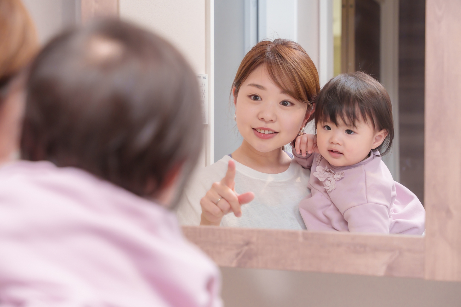 鏡をのぞく親子