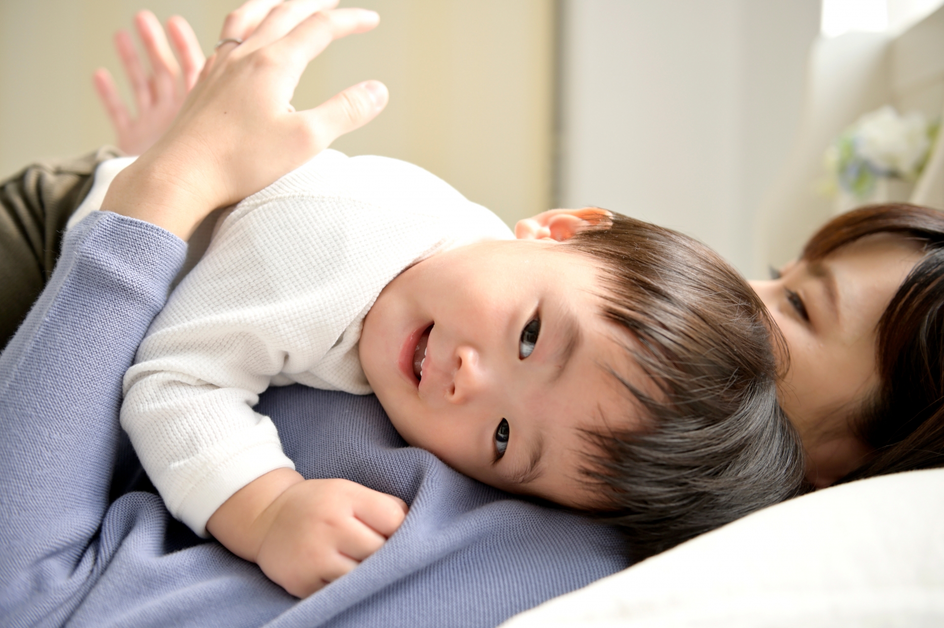 ママの上に寝転ぶ赤ちゃん