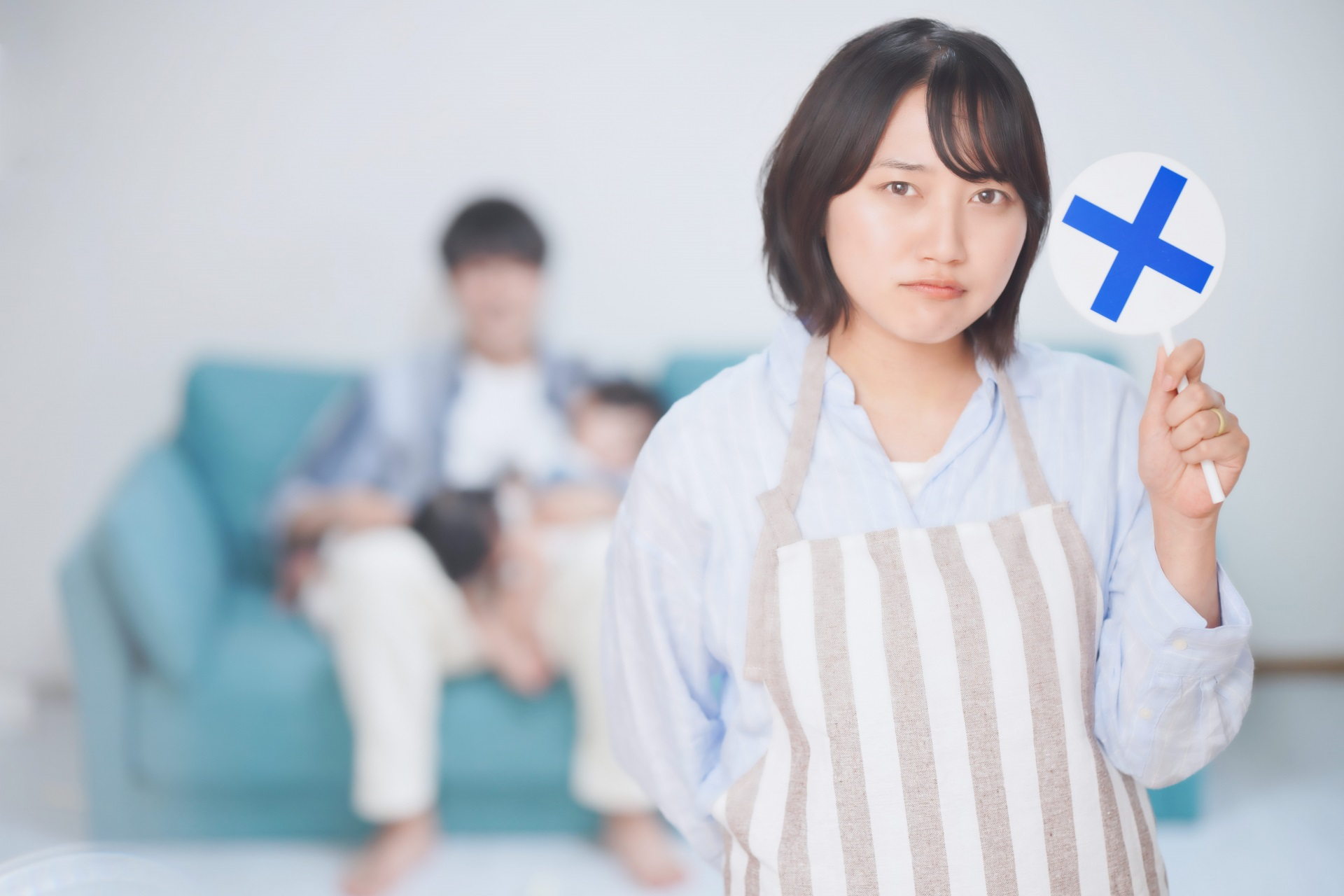 ✕の札をもつママ