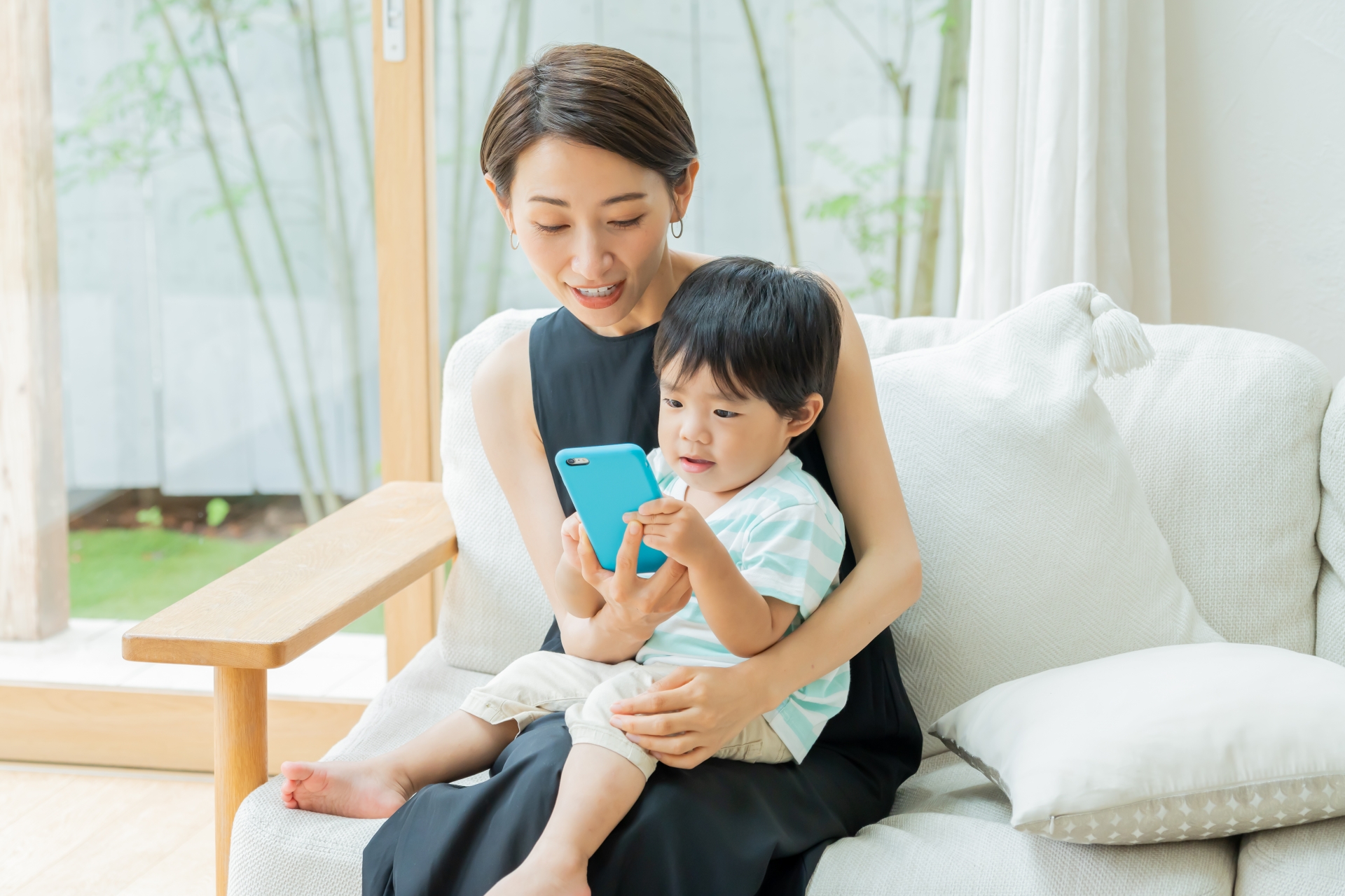 一緒にスマホをみる親子