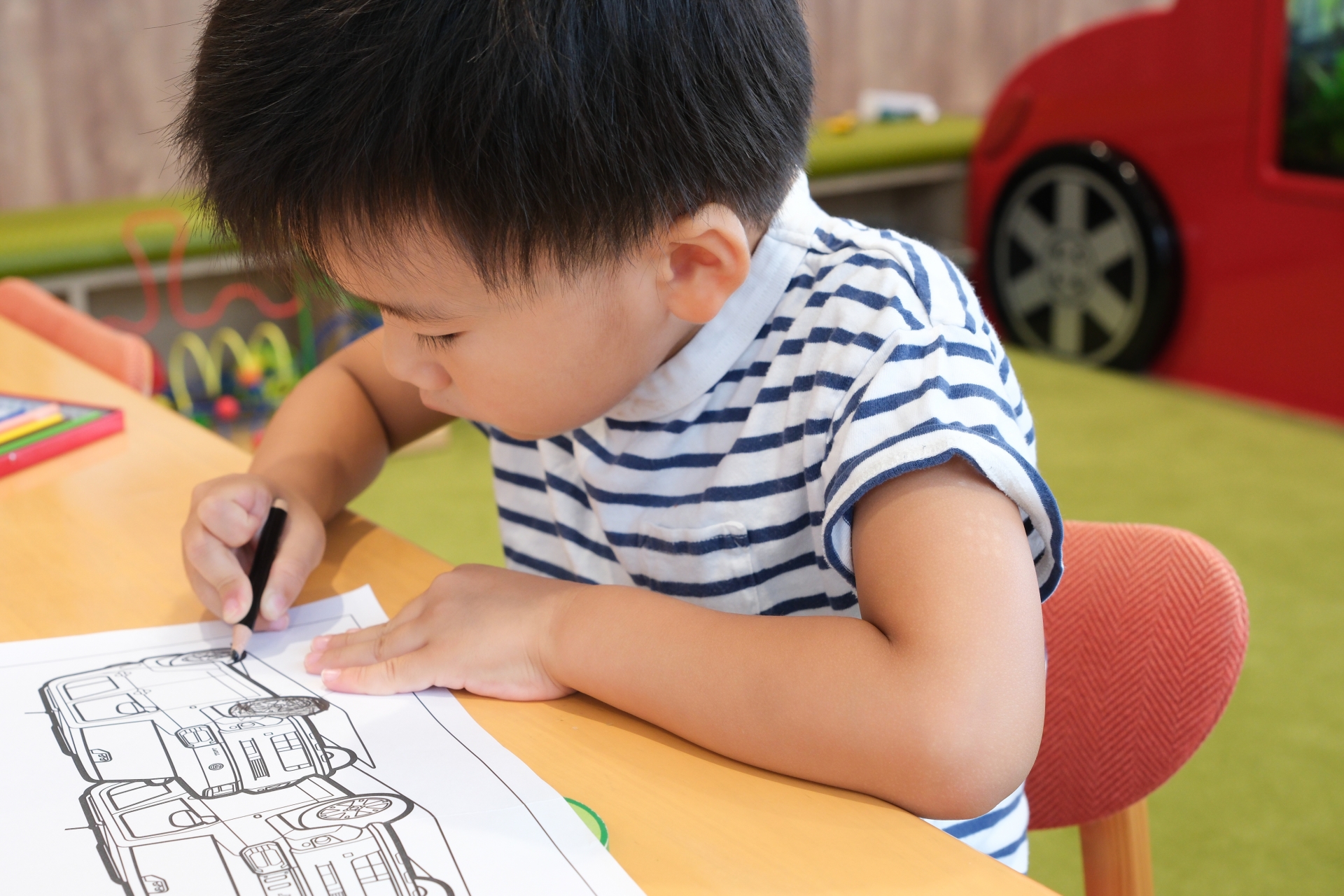 車の絵の塗り絵をする男の子