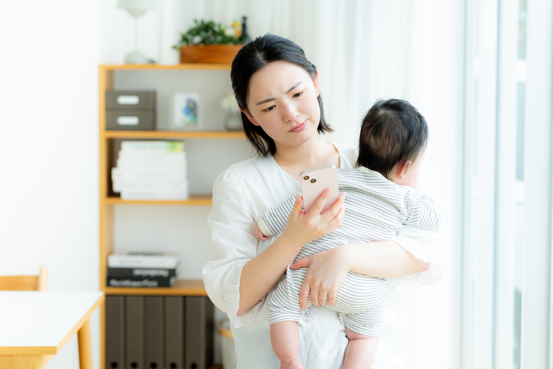 スマホとにらめっこするママ